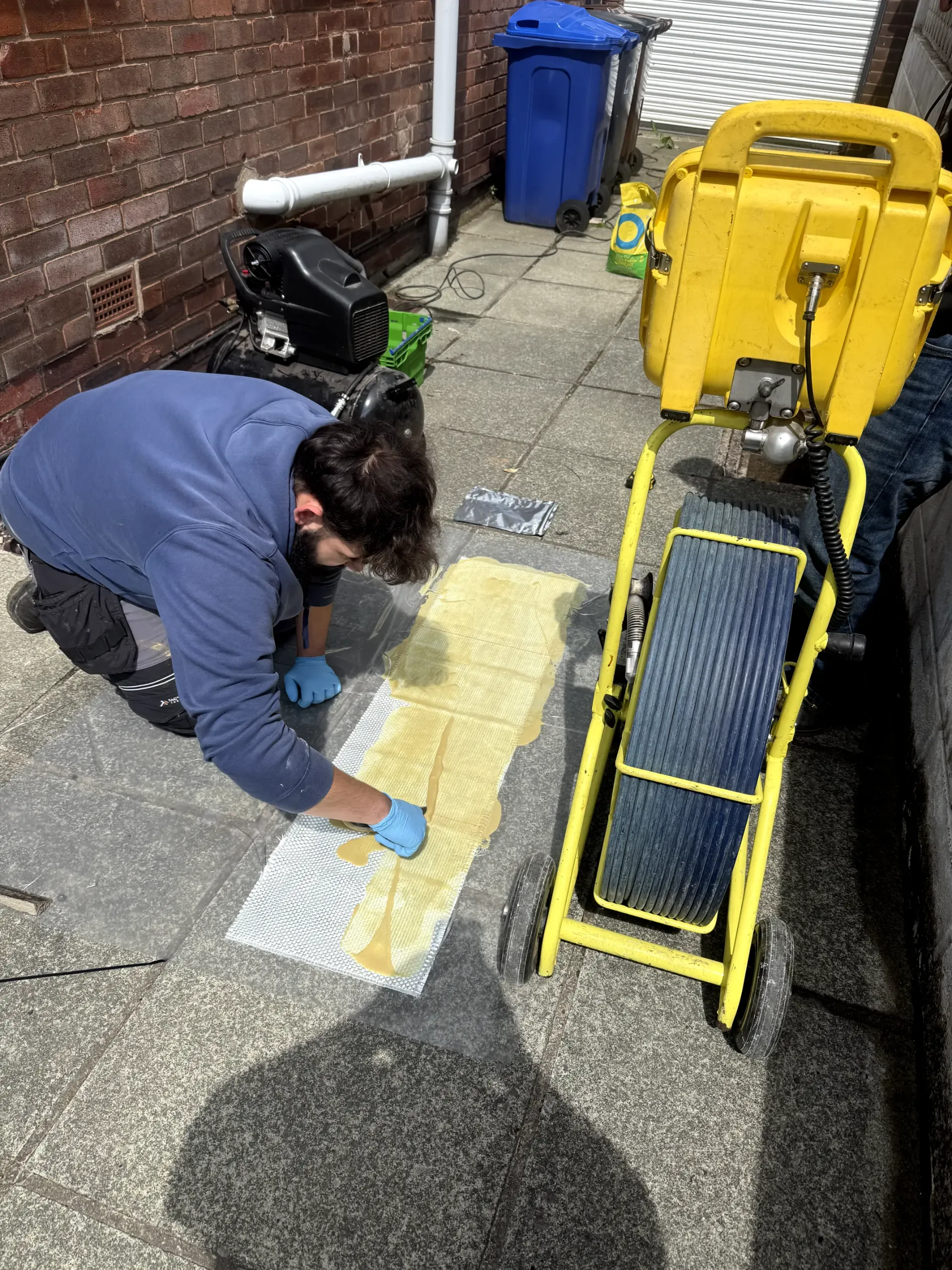WGS Services engineer preparing a trenchless pipe lining patch for no-dig drain repair in Darwen